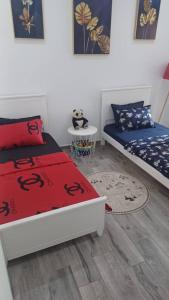 a bedroom with two beds and a table with a rug at Fernand ville Oran in Oran