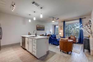 a kitchen with a sink and a living room at Gorgeous Riverwalk View Condo 1241 in San Antonio