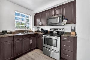 a kitchen with brown cabinets and a stove top oven at Miami stays vacations in Miami