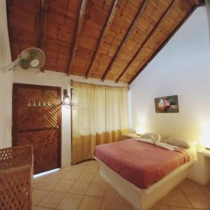 una camera con letto e soffitto in legno di Habitaciones en Vichayito a Vichayito