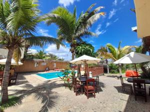 een resort met een zwembad, stoelen en palmbomen bij Habitaciones en Vichayito in Vichayito