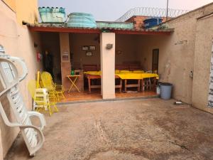 eine Terrasse mit einem gelben Tisch und Stühlen in der Unterkunft Casa para Temporada Agrishow 2024 in Ribeirão Preto
