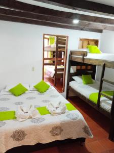 a room with two bunk beds with towels on them at Hospedería Villa Lucía in Villa de Leyva
