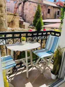 d'une table blanche et de deux chaises sur un balcon. dans l'établissement Marcel Zadar Old Town, à Zadar