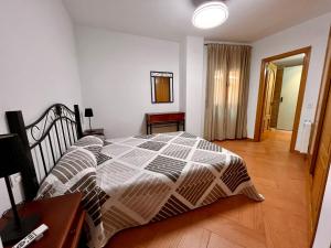 a bedroom with a bed and a wooden floor at APARTAMENTOS TURISTICOS MONTASOL in Montánchez