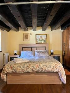Un dormitorio con una cama grande con dos mesitas de noche. en La Posada de Izan, en Gumiel de Hizán