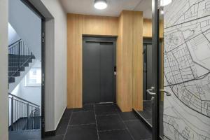 um corredor com uma porta preta e um mapa na parede em L7 Warsaw Apartments Sauna&Gym em Varsóvia