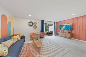 sala de estar con sofá azul y TV en New Luxury Listing! Walking distance to shops, lake & beach, en Destin