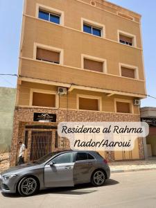 een auto geparkeerd voor een gebouw bij Residence al Rahma 02 in Monte ʼArrouit