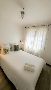 sypialnia z dużym białym łóżkiem z białymi zasłonami w obiekcie Appartement avec une chambre w mieście Arles