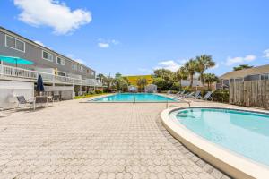a swimming pool with a patio and a building at New Luxury Listing! Walking distance to shops, lake & beach in Destin