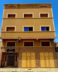 Un edificio alto con dos puertas de garaje. en Residence al Rahma 02, en Monte ʼArrouit