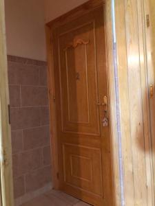 a wooden door in a bathroom with a shower at Residence al Rahma 02 in Monte ʼArrouit