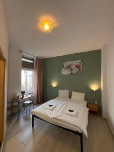 ein Schlafzimmer mit einem weißen Bett und einer grünen Wand in der Unterkunft Stadtoase im Herzen Berlins in Berlin
