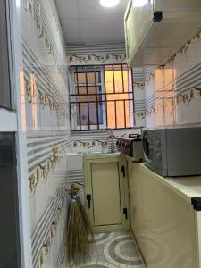 a small kitchen with a sink and a microwave at A Cosy Room and a Parlor-Self in Ikeja