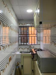 a small kitchen with a sink and a window at A Cosy Room and a Parlor-Self in Ikeja