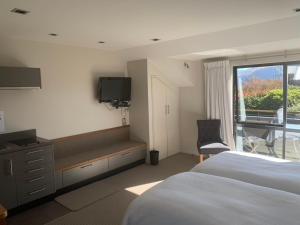 una camera da letto con un letto, una tv e una finestra di Aspiringlofts a Wanaka