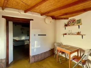 a room with a table and chairs and a bedroom at Casa Ckamur - refugio de adobe in San Pedro de Atacama
