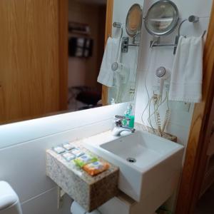 y baño con lavabo y espejo. en Flat sem café da manhã - Cullinan (SHN Brasília), en Brasilia