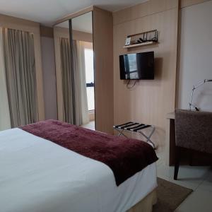 um quarto com uma cama e uma televisão de ecrã plano em Flat sem café da manhã - Cullinan (SHN Brasília) em Brasília