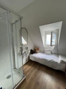 a bedroom with a bed and a glass shower at Petites chambres rénovées 2024 Paris 17e in Paris