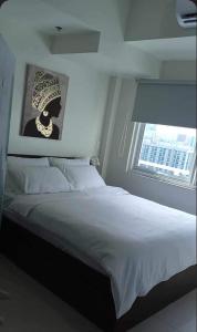 a bedroom with a large white bed with a window at Brand new and fully furnished home away from home! in Manila