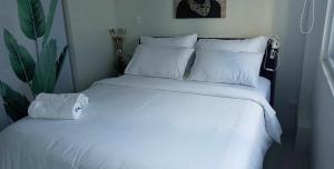 a white bed with white sheets and pillows at Brand new and fully furnished home away from home! in Manila
