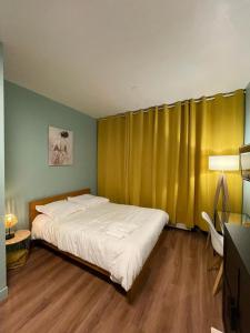 メスにあるCozy studio Metzのベッドルーム(ベッド1台、黄色のカーテン付)