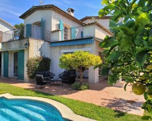 a villa with a swimming pool in front of a house at Juan les pins : Villa de charme avec piscine in Juan-les-Pins