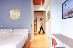 - une chambre avec un lit et une personne se déplaçant dans un couloir dans l'établissement Acre Urban Studios in Monastiraki, à Athènes