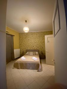 1 dormitorio con cama y pared de ladrillo en Marina's house, en Salamina