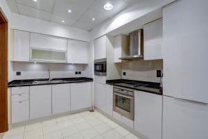 - une cuisine blanche avec des armoires et des appareils blancs dans l'établissement Oceana Atlantic Seaside Apt, à Dubaï