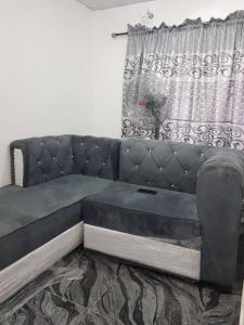 a black couch in a living room with a window at A Cosy Room and a Parlor-Self in Ikeja