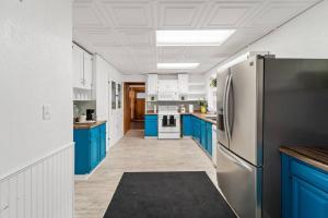 een keuken met blauwe kasten en een koelkast bij The Vintage Haven in Des Moines