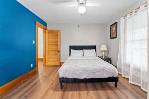 een slaapkamer met een bed en een blauwe muur bij The Vintage Haven in Des Moines