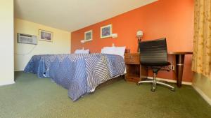 1 dormitorio con cama, escritorio y ordenador en Travelors Lodge Motel & RV Park US-287&US-96, en Eads