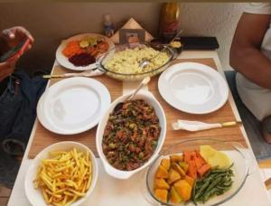 stół z talerzami żywności i miskami żywności w obiekcie Splanada poilon w mieście Assomada