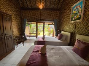 um quarto de hotel com duas camas e uma janela em Tebu menjangan homestay em Banyuwedang