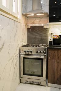 cocina con horno de acero inoxidable en شقة فندقية مفروشة, en Ḩulwān