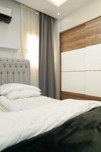 Un dormitorio con una gran cama blanca y una ventana en شقة فندقية مفروشة, en Ḩulwān