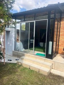 une extension en verre d'une maison avec un patio dans l'établissement Triple T Guest house, à Johannesbourg