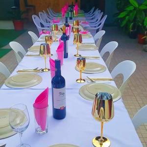 uma longa mesa com garrafas de vinho e copos em Splanada poilon em Assomada