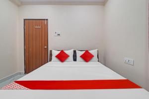 um quarto com uma cama com almofadas vermelhas e brancas em Hotel SV Grand em Hyderabad