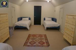 ein Schlafzimmer mit 2 Betten und einem Teppich auf dem Boden in der Unterkunft SookeDreams in Sooke