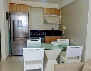 a kitchen with a table and chairs and a refrigerator at CJC Short Stay Natal in Natal