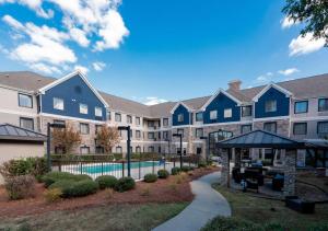 a large apartment building with a swimming pool at Staybridge Suites Jackson, an IHG Hotel in Ridgeland