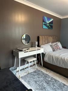 a bedroom with a desk with a bed and a mirror at Amazing Ground Floor one bedroom apartment Forest Road in London