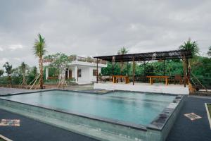 a swimming pool in front of a house at The Akasea Villa Bali in Ungasan