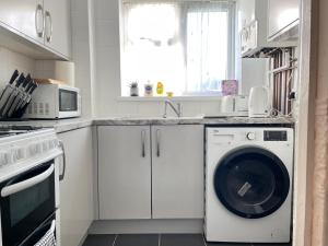 a white kitchen with a washing machine in it at Long Stays in Birmingham - 1 Bedrooms, 1 Baths, 2 Separate Beds & Parking in Birmingham