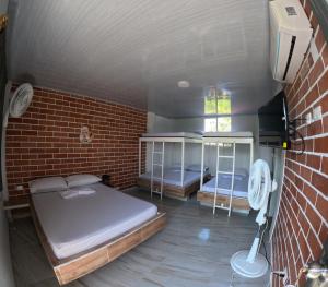 Habitación con 2 camas y pared de ladrillo en Cabaña la Gloria, en San Onofre